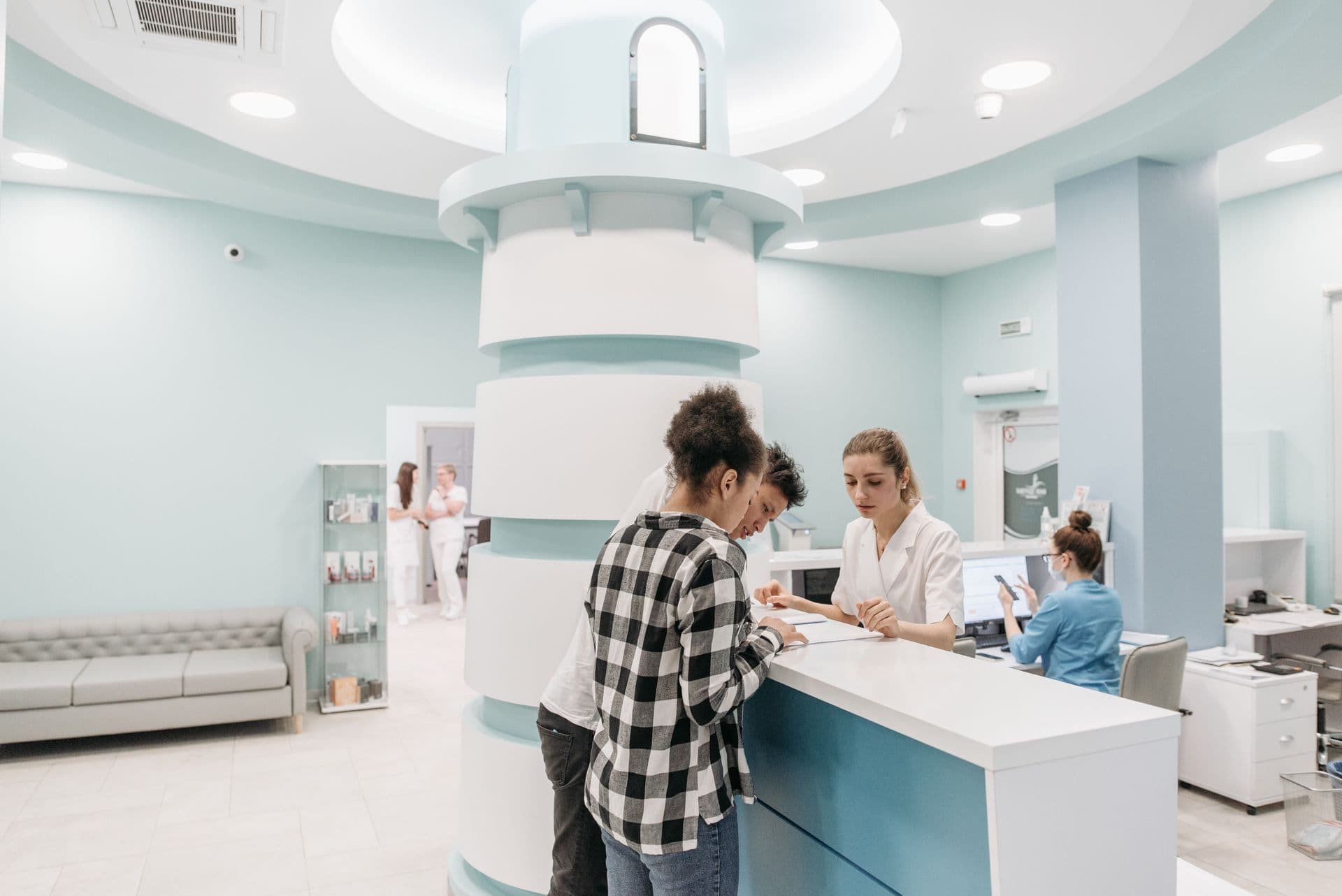 The bright reception area at Willowbrook Surgery, with patients checking in at the front desk